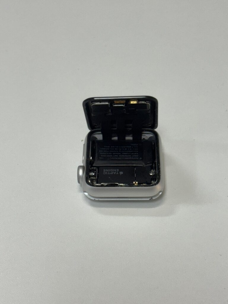 分解されたApple Watch Series 3の内部構造。画面が開いた状態でバッテリー交換準備中