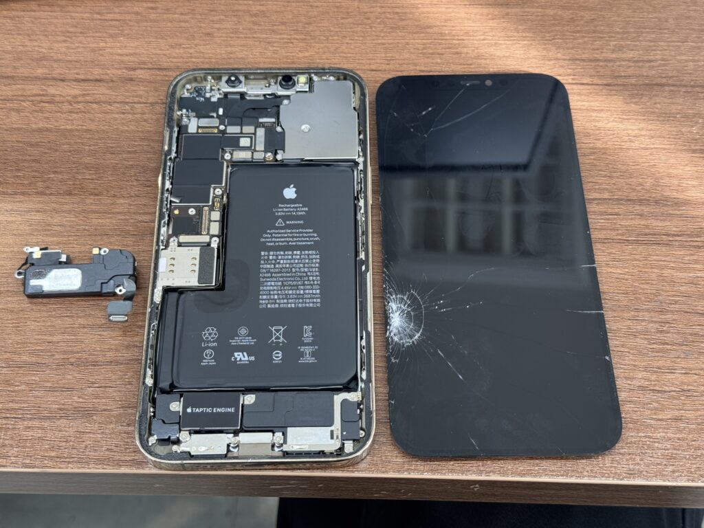 iPhone12 Pro Maxの画面交換作業のため、本体を開き内部のパーツを確認している修理工程