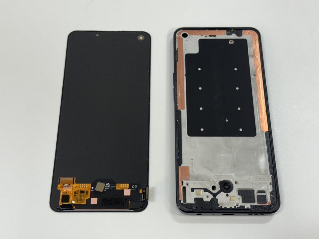 背面パネルを取り外し、内部の基板カバーや液晶コネクタが見える状態のOPPO Reno7Aの修理工程