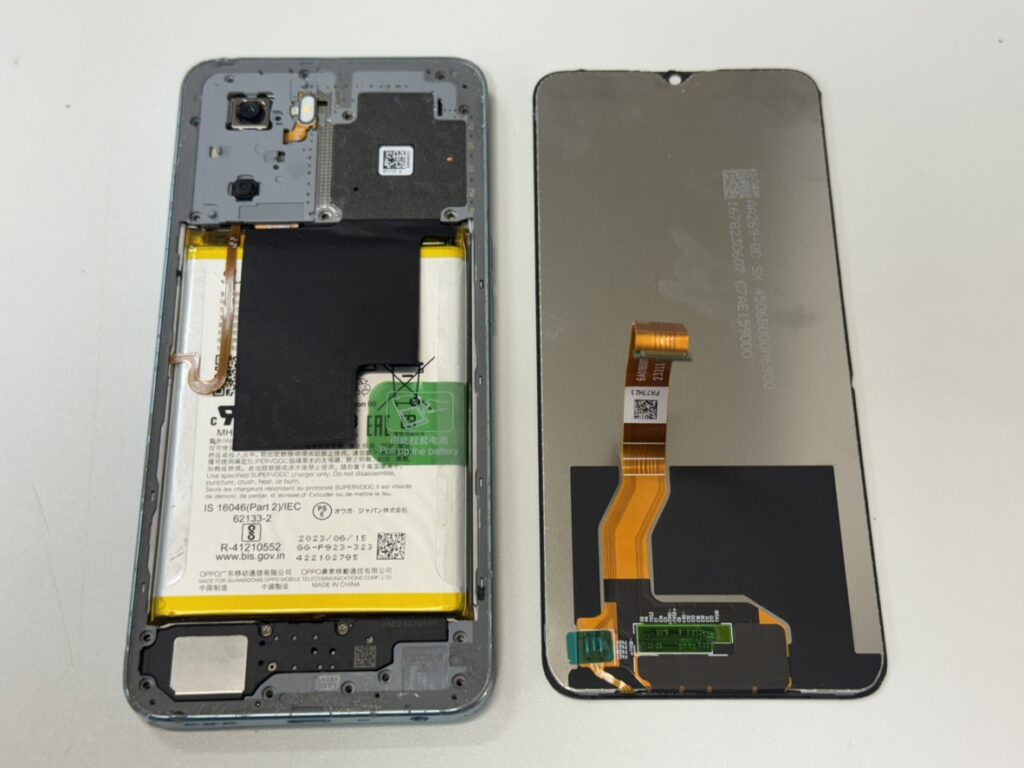 背面パネルを取り外し内部基板から古い液晶パネルを慎重に交換しているOPPO A77