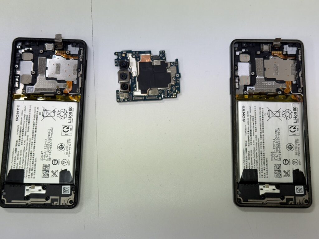 Xperia 8 liteの背面を開き、基板やSIMトレーを取り外している移植作業の様子。