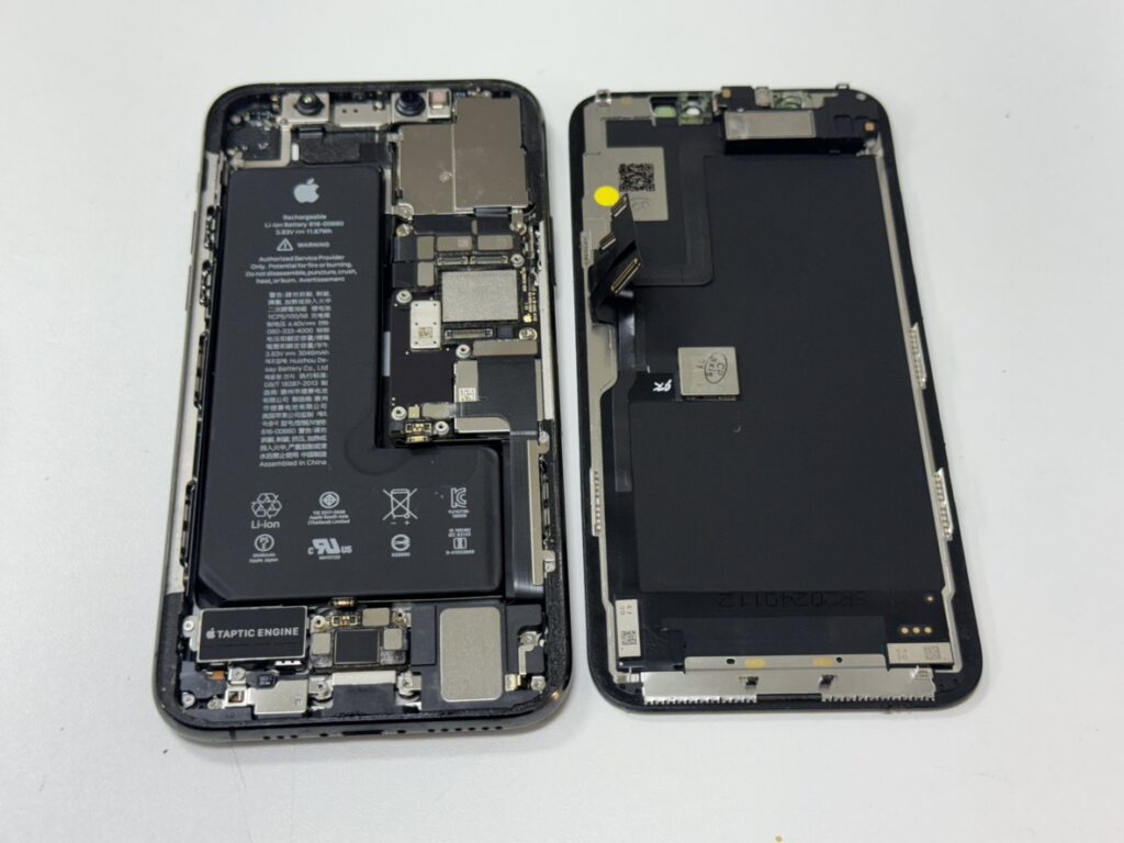 iPhone 11 Proの内部。基板から故障した画面コネクタを取り外している修理工程。