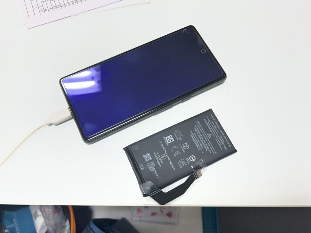 左側に劣化した古いバッテリー、右側にこれから交換する新品のGoogle Pixel 7a用高品質バッテリーを並べた比較写真