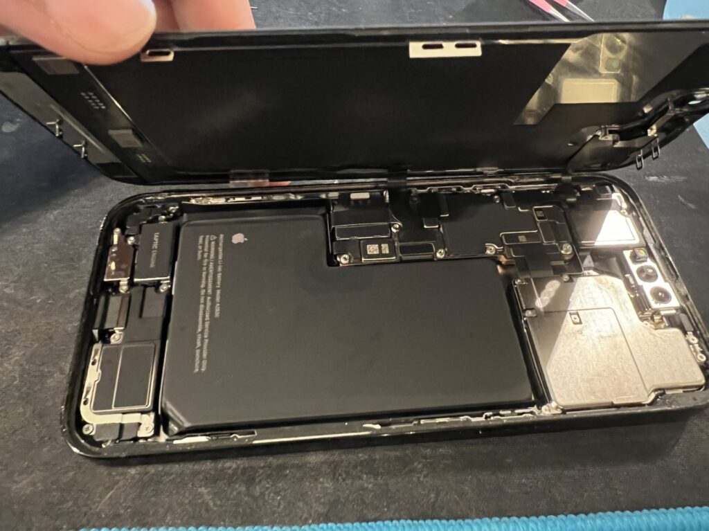 横浜の修理店でiPhone14ProMaxを精密に分解し画面を外す風景