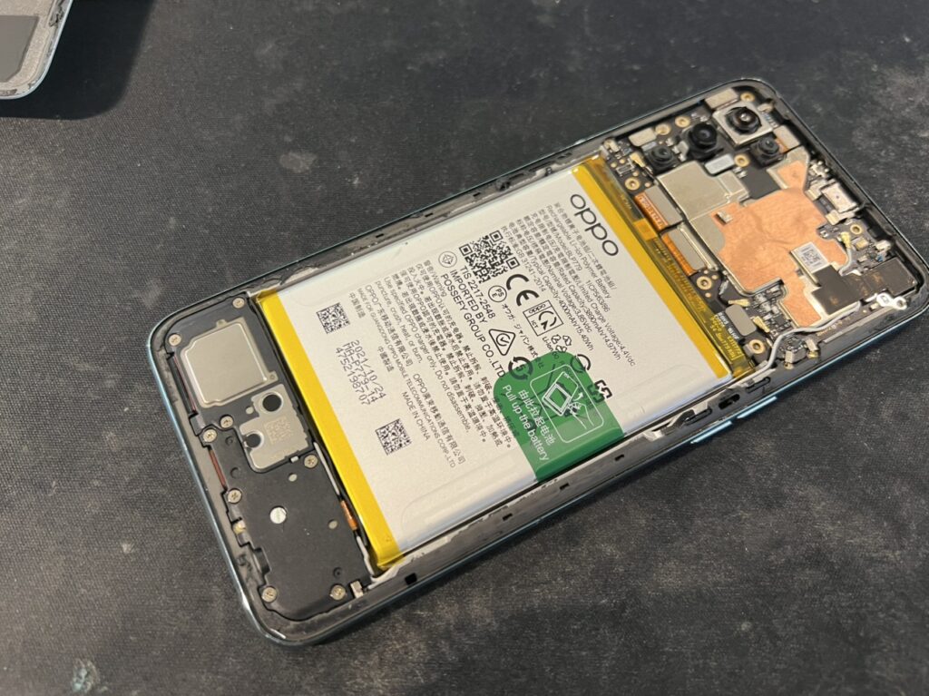 OPPO Reno5Aの背面パネルを慎重に開封しバッテリーを交換する様子