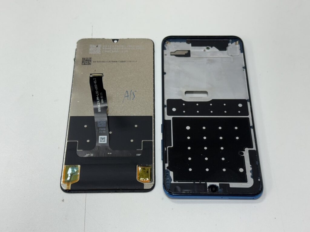 HUAWEI P30 liteの背面を開き、基板から古い液晶パネルの接点を外している修理風景。