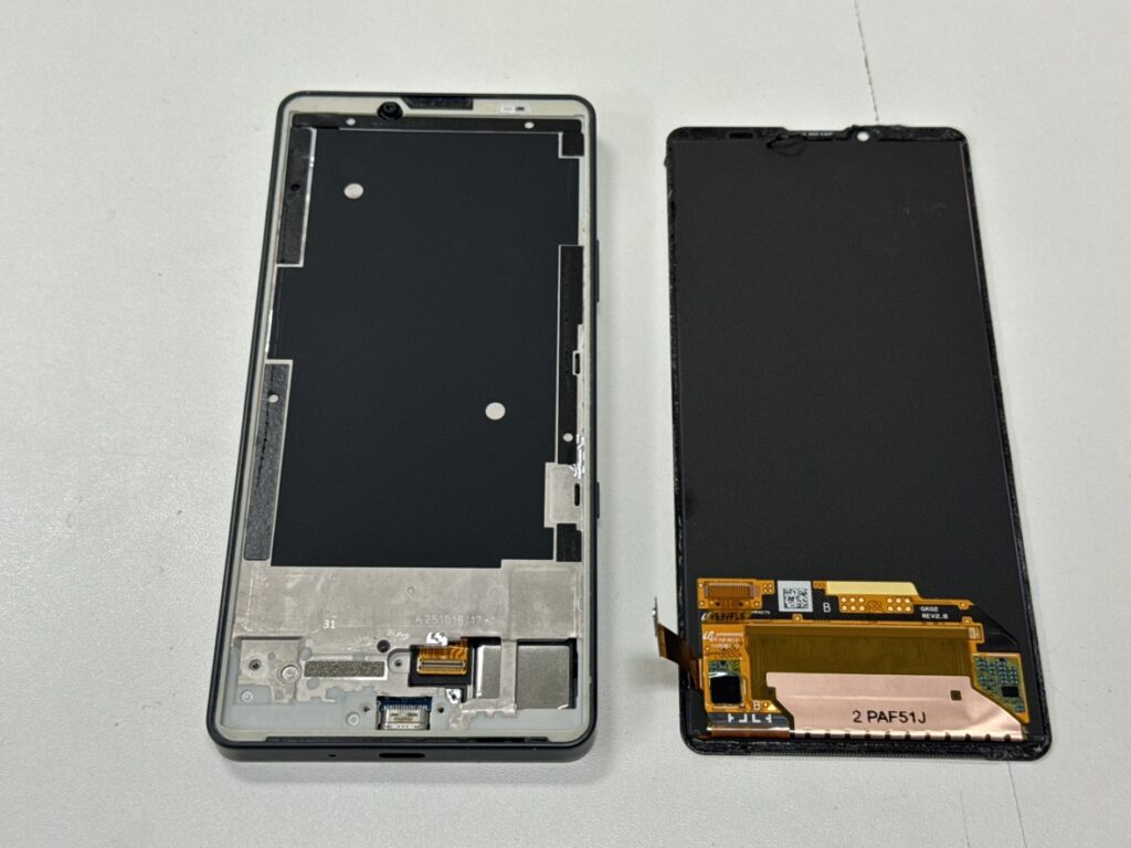 Xperia 10 VIIの内部。基板から古いディスプレイコネクタを取り外し、新しいパネルを準備している様子。