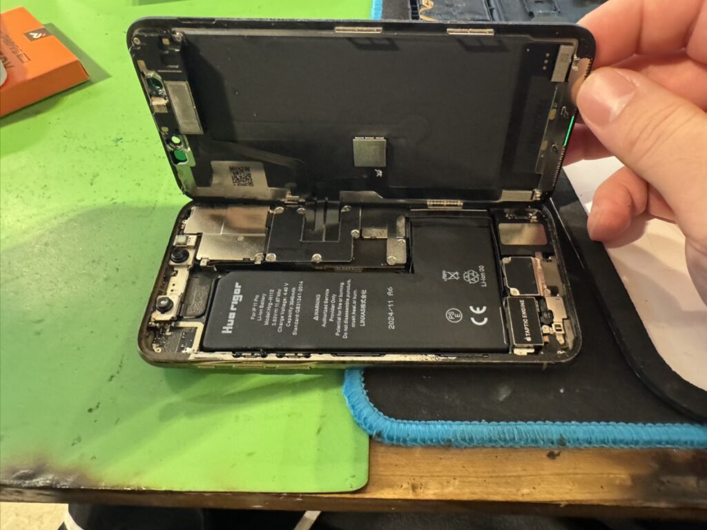 フェニックス関内本店でiPhone 11 Proの画面を慎重に外し、内部を清掃する様子