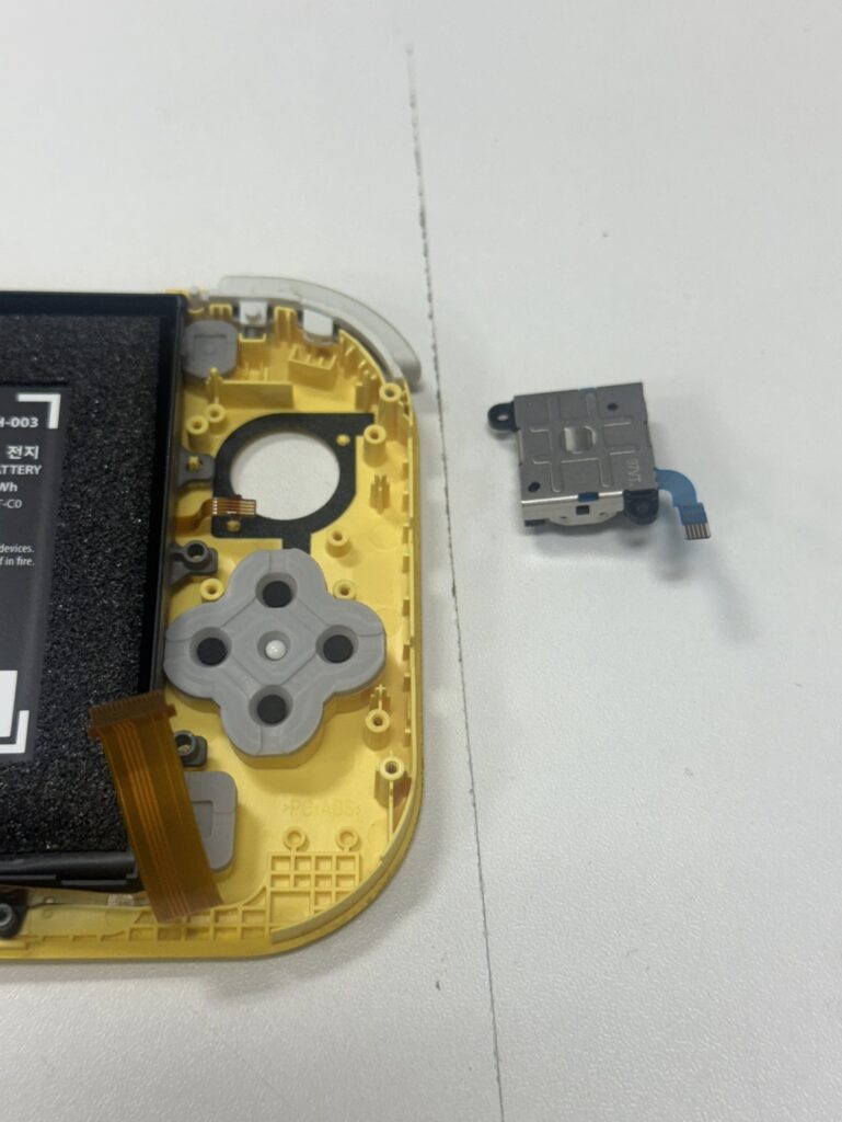 Switch Liteの内部から故障パーツを外す様子。
