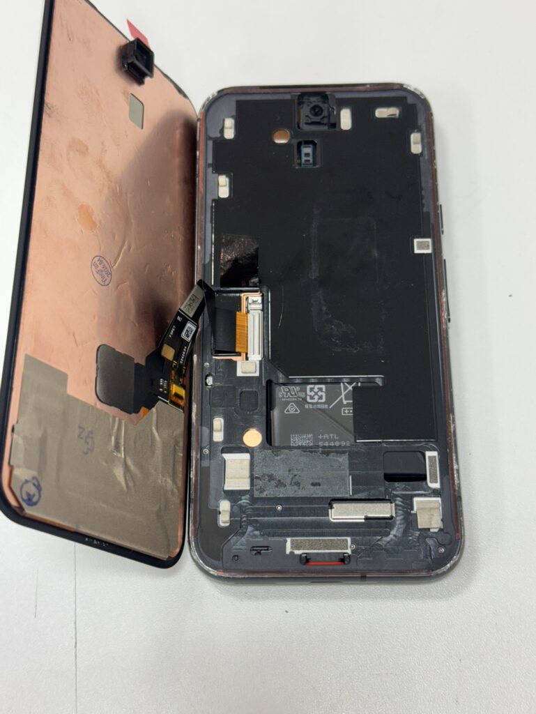 Pixel 8aの前面パネルを取り外す様子。