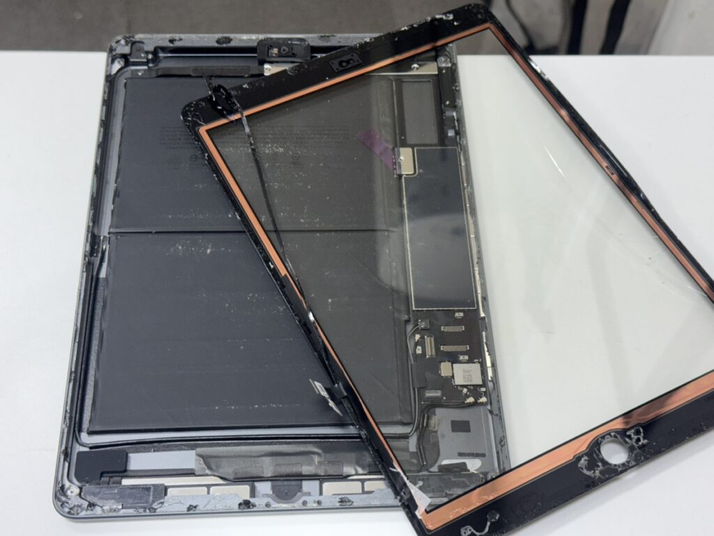 iPad 8から割れたガラスを慎重に剥がす様子。