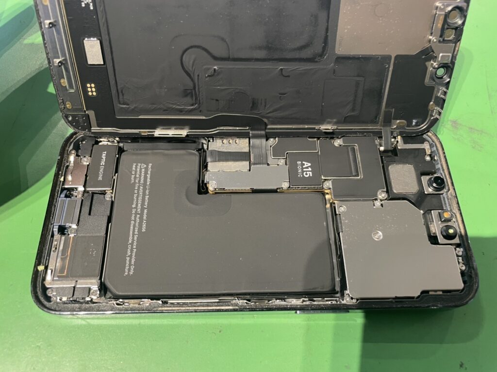フェニックス横浜関内本店の熟練技術者が、iPhone13Proの内部配線を傷つけないよう慎重に画面を分解している様子