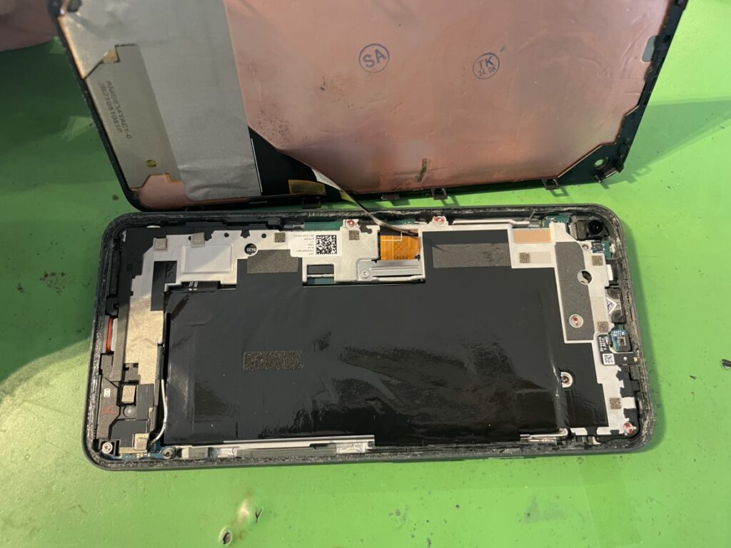 フェニックス横浜関内本店の技術者がPixel5aの内部基板を傷つけないよう慎重に液晶パネルを取り外している様子