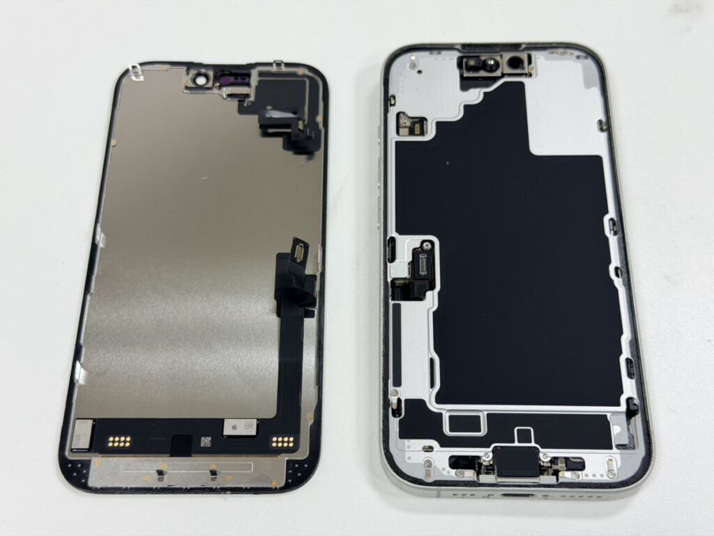 iPhone 16の画面を開き、内部のコネクタを取り外している修理の様子