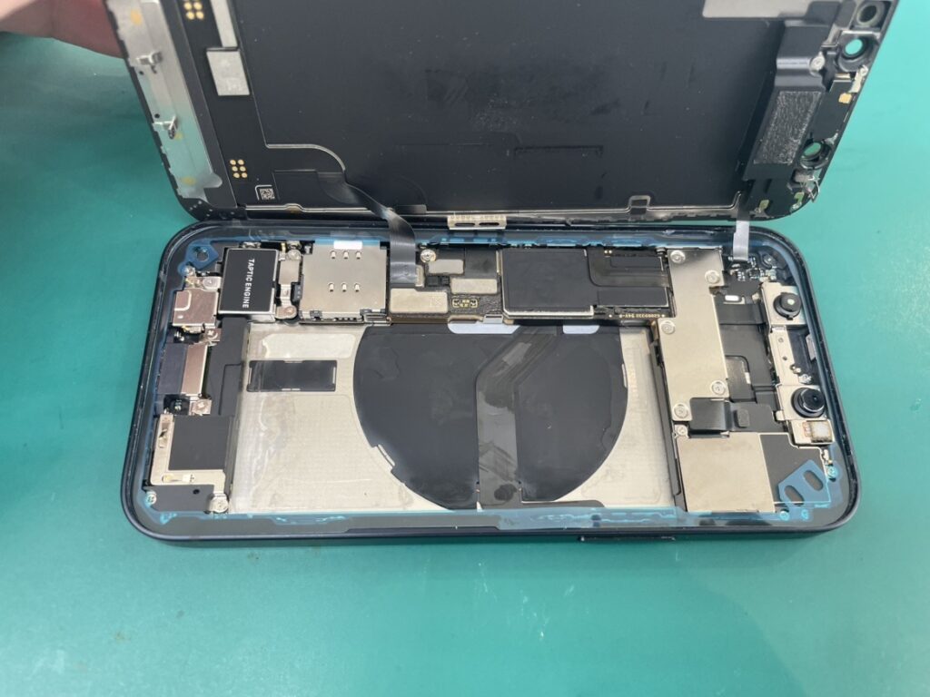 フェニックス横浜関内本店の技術者がiPhone12miniの画面を安全に開き、古い劣化したバッテリーを丁寧に取り外している様子
