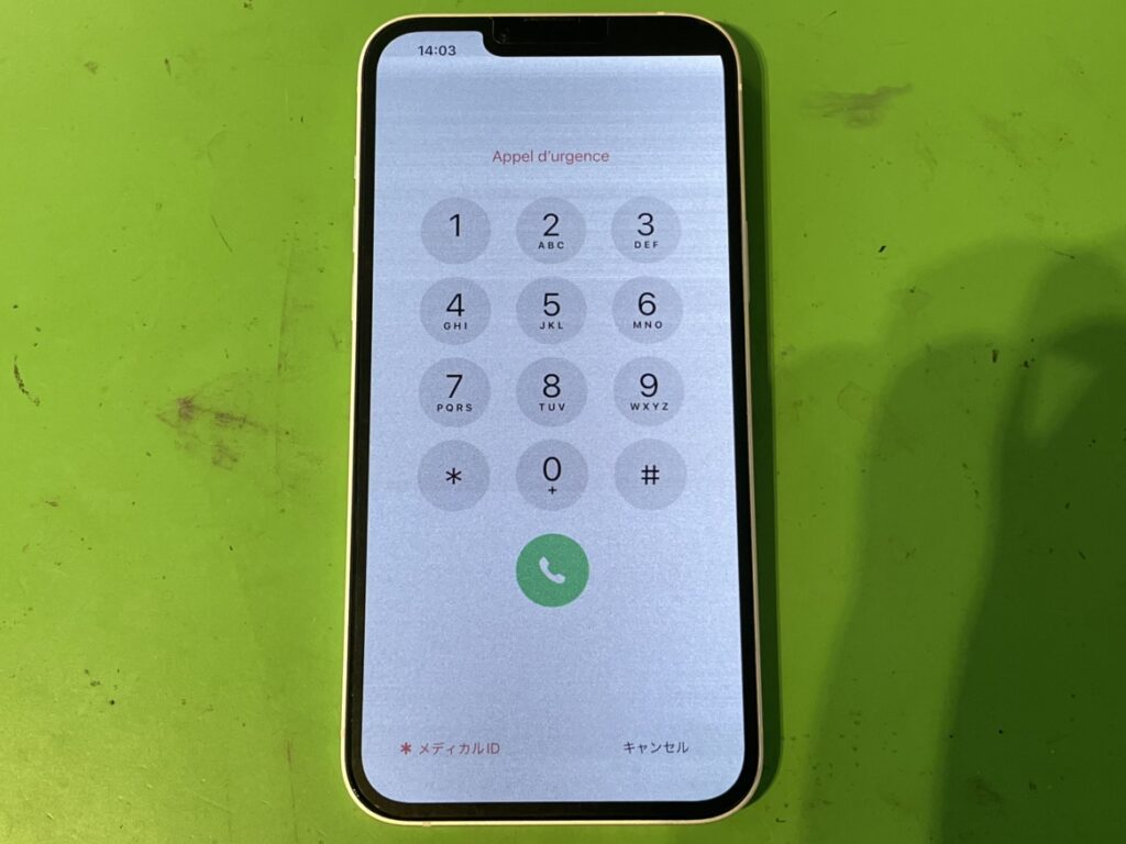 落とした衝撃で画面の右上が黒く変色し、表示不良が起きているiPhone14