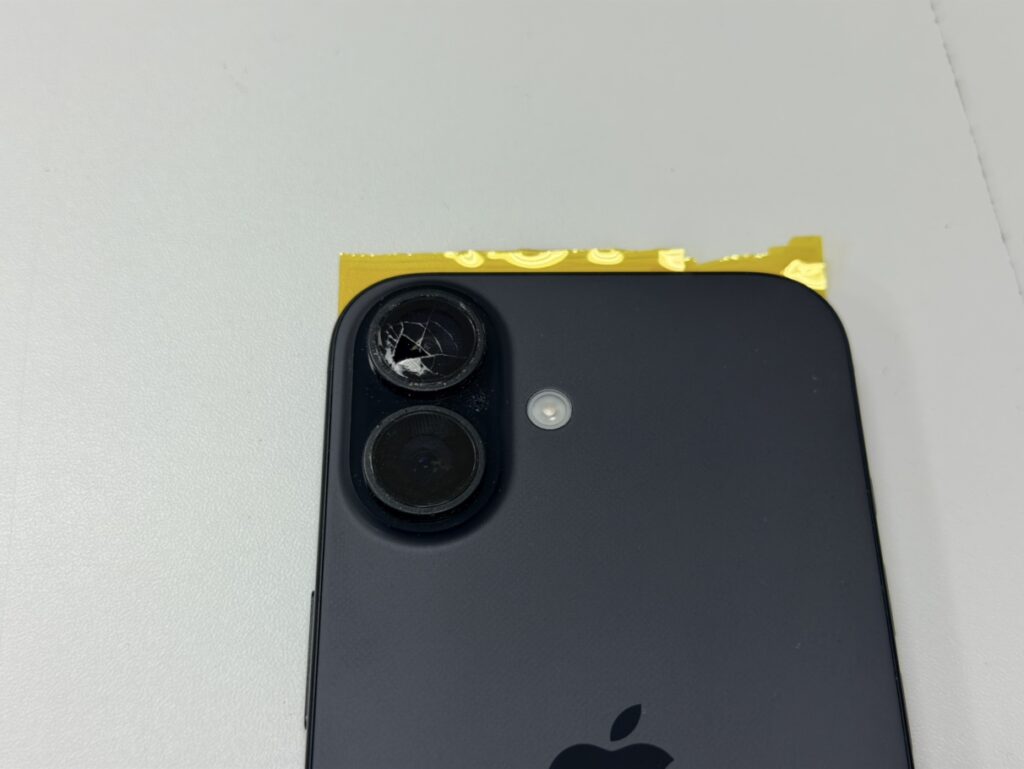 背面の上側にあるメインカメラレンズガラスが激しくひび割れてしまったiPhone 16。