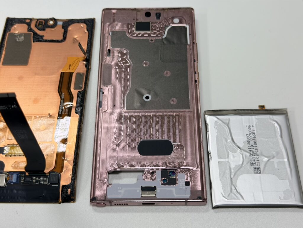 Galaxy Note20 Ultraの背面を開き、画面パーツと膨張したバッテリーを分解している様子。